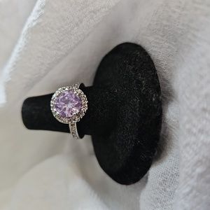 Light purple round stone ring with a halo of clear stones